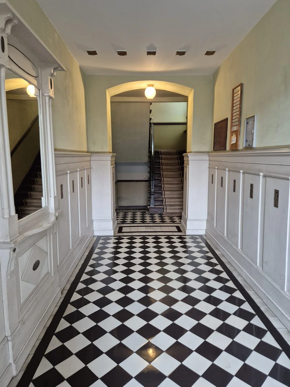 Gepflegter Innenhof mit Rosenbeeten an einem Wohnhaus